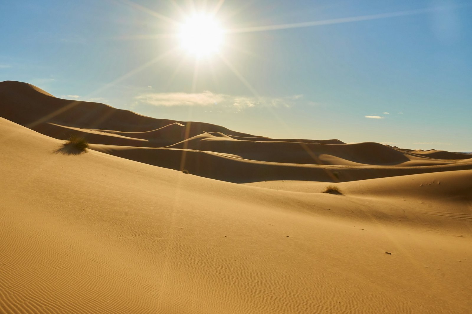 Sand dunes and blue sky with sun